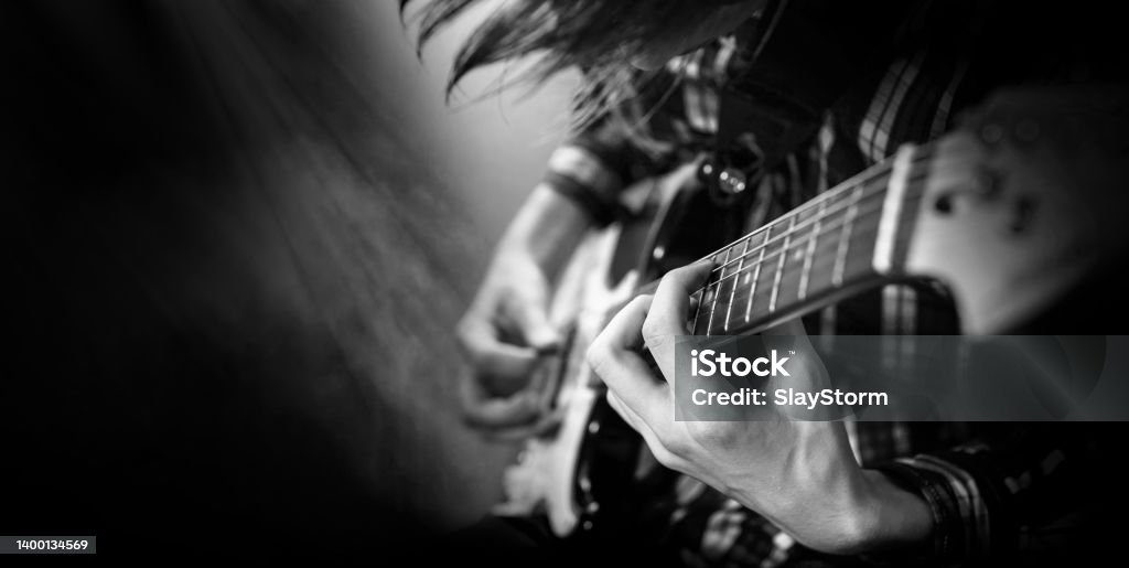 Electric guitar playing. Young men playing electric guitar Electric guitar playing. Young men playing electric guitar. Black and white closeup Photography. Popular Music Concert Stock Photo