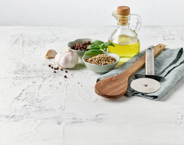 Ingredients and spices background. Decanter of cooking oil, tomatoes, rosemary, garlic and mixed dry pepper on black rough background.