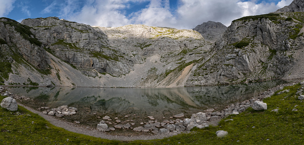 Lower Krisko Lake (Spodnje Kriško jezero) in the heart of mountain peaks at Kriški Podi,  Triglav national park, Julian Alps