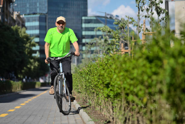 A man is cycling on a bike lane in the city.