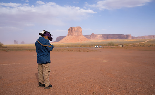 Kid with remote control in his hands  flying a drone in Monument Valley