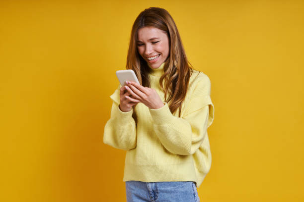 istock Happy young woman using her smart phone 1400144126