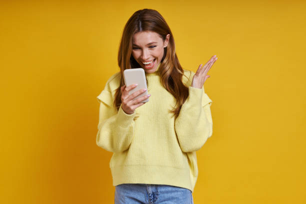 istock Excited young woman using her smart phone 1400144149