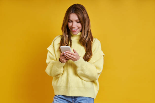 istock Happy young woman using her smart phone 1400144165