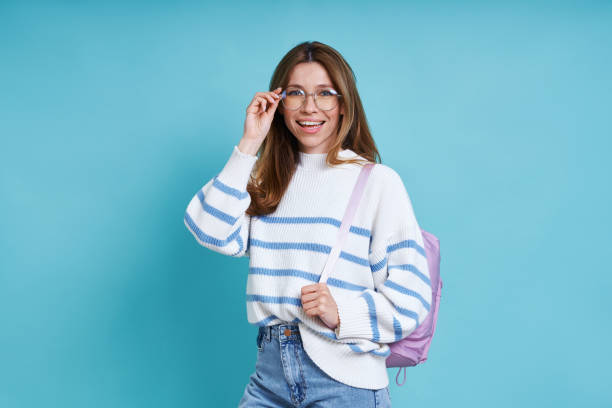 istock Happy female student with backpack adjusting glasses 1400144371