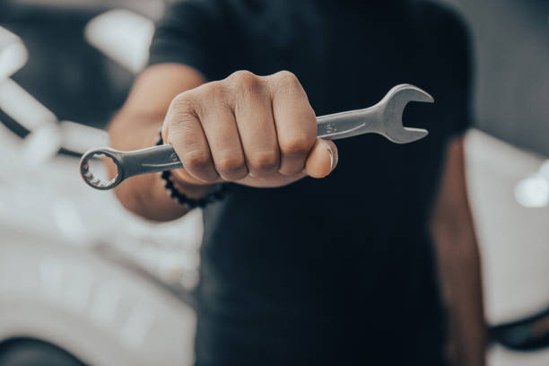 istock Hand holding a wrench with a car repairs 1400145880