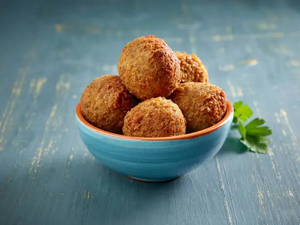 bowl of fried falafel balls on blue wood table