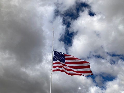 Dramatic Sky Above US Flag at Half Mast
