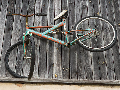 Classic style grey vintage Dutch bicycle in front of brick wall.