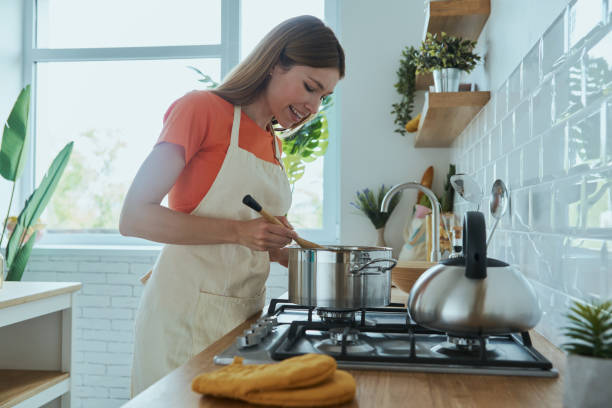 istock Confident young woman cooking soup while standing at the domestic kitchen 1400148810