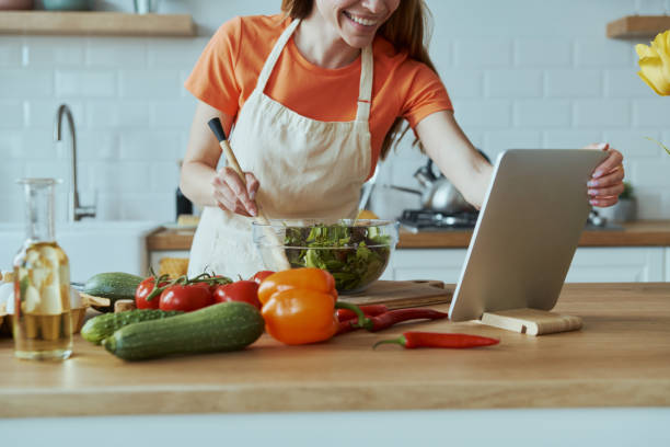 istock Close-up of young woman cooking and using digital tablet 1400149002