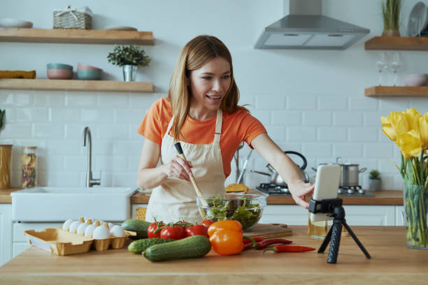 istock Cheerful young woman cooking and vlogging 1400149020