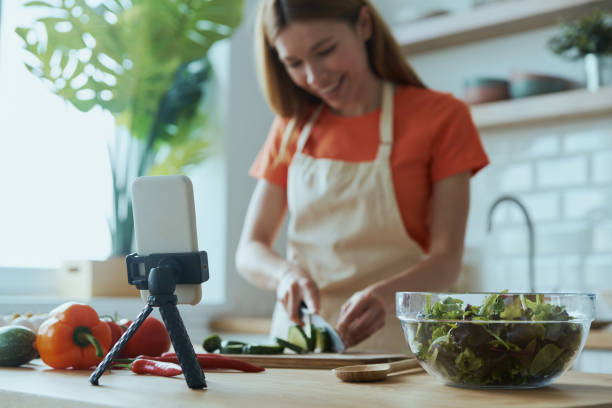 istock Cheerful young woman cooking and vlogging 1400149039