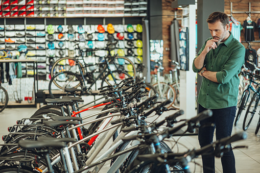 man checking out bicycles in bike shop