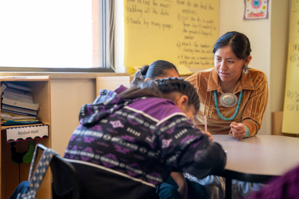 istock Young Female Teacher Assisting Elementary Age Students in Class Room at an Elementary School 1400149200