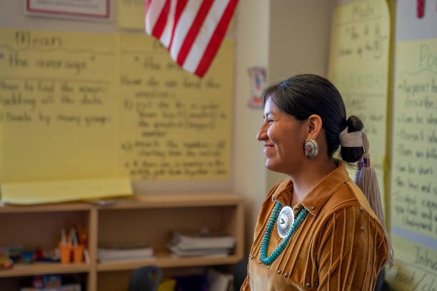giovane insegnante sorridente nella parte anteriore della sua classe coinvolgendo e insegnando ai suoi giovani studenti - navajo american culture indigenous culture women foto e immagini stock