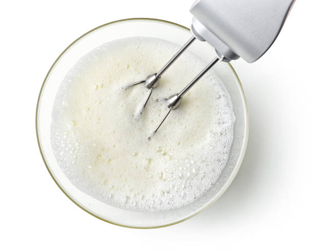 beating egg whites cream with mixer in the bowl beating egg whites cream with mixer in the bowl isolated on white background, top view egg white stock pictures, royalty-free photos & images
