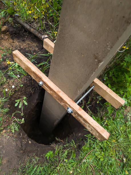 dig a deep hole in the soil to pour mortar on the fence posts to strengthen the foundation. - post processing imagens e fotografias de stock