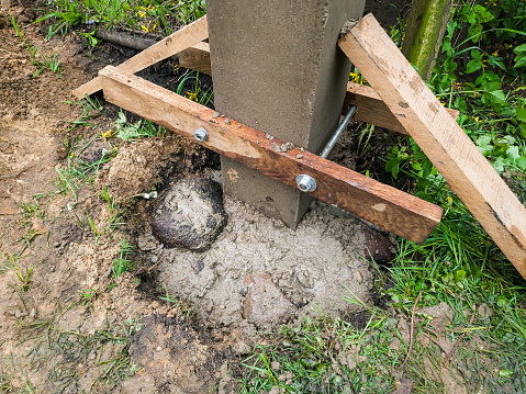 Dig a deep hole in the soil to pour mortar on the fence posts to strengthen the foundation.