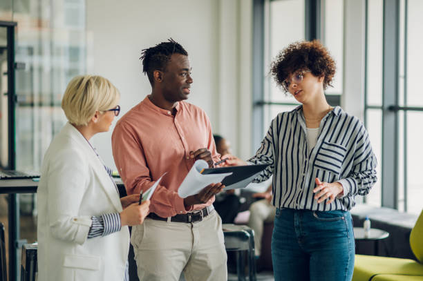 istock Multiracial business colleagues discussing about documents in the office 1400153644