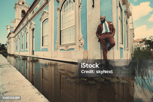istock Black man and a blue house with pond 1400155189