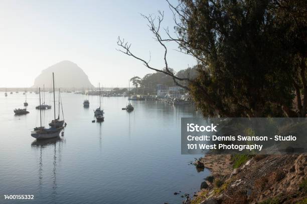 Foggy Landscape Of Morro Bay With Calm Water With Sailboats Moored Throughout Stock Photo - Download Image Now