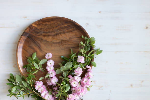 istock Round teak tray with spring pink blossoms on white 1400156346
