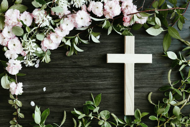 istock Cross framed by flowers on dark wood 1400156354