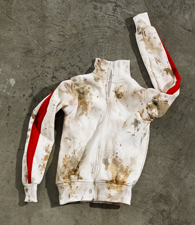 Looking down on  a muddy, dirty, satiny track jacket