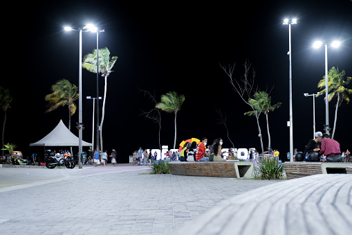 João Pessoa, Paraíba, Brazil - October 15, 2021:People having fun in Bust de Tamandaré town square, Cabo branco beach at night.