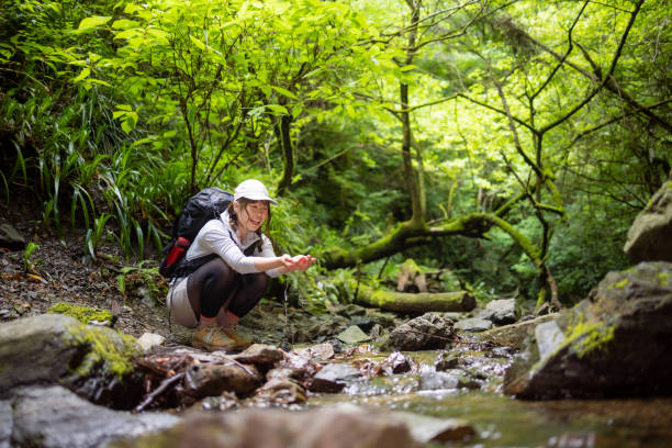 istock Woman washing hands with river water 1400164338