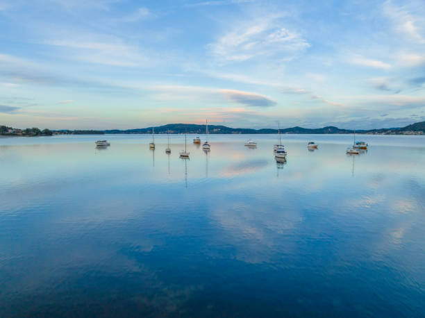 Soft blue sunset with boats, clouds and reflections at Koolewong and Tascott on the Central Coast, NSW, Australia.