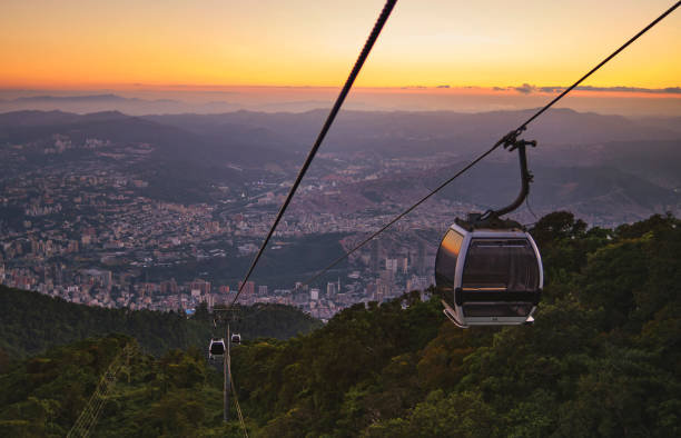 istock Modular cabins cable car against the bright sky, clouds ans mountains. Cableway - one of the popular urban rides in Caracas. toned image. 1400166989