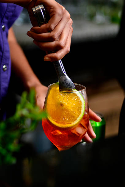 istock Bartender preparing refreshing drink with fruit in a fancy bar on a dark background. 1400167934