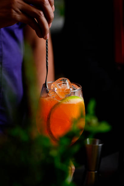 istock Bartender preparing refreshing drink with fruit in a fancy bar on a dark background. 1400167977