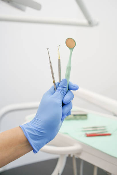 istock hand with glove holds professional dental instruments including mirror, modern object for health, studio 1400174040
