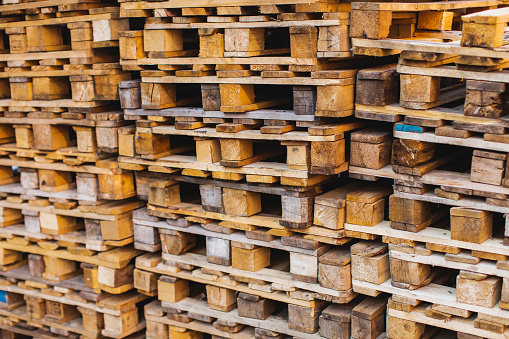 Heap of Wooden Pallets in Storage Warehouse.