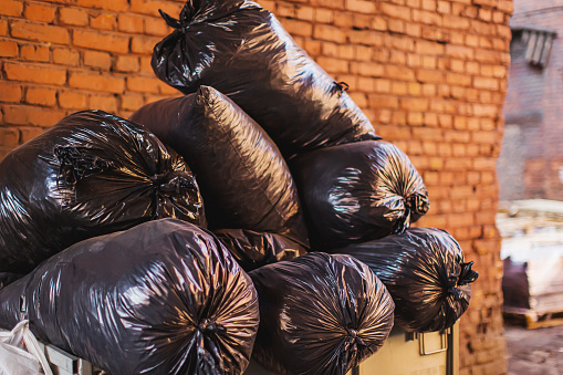 Black full garbage bag in landfill.