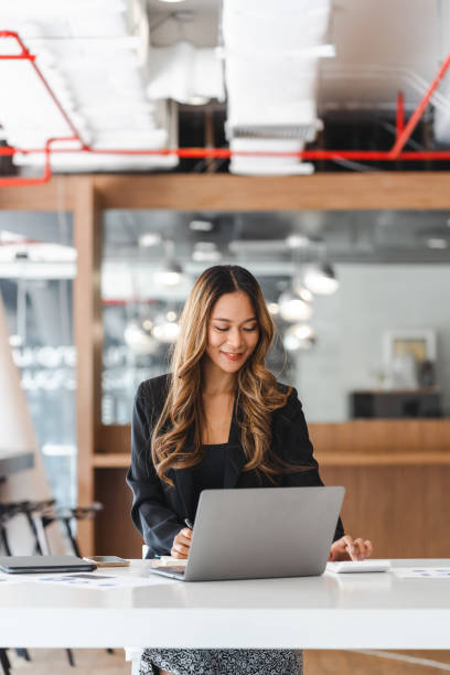 istock Business women using calculator at working with financial report. 1400176256