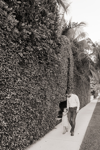 31-Year-Old American Father Walking Down a Sidewalk With His 3-Year-Old Daughter While Holding Hands in Palm Beach, Florida in the Spring of 2022.