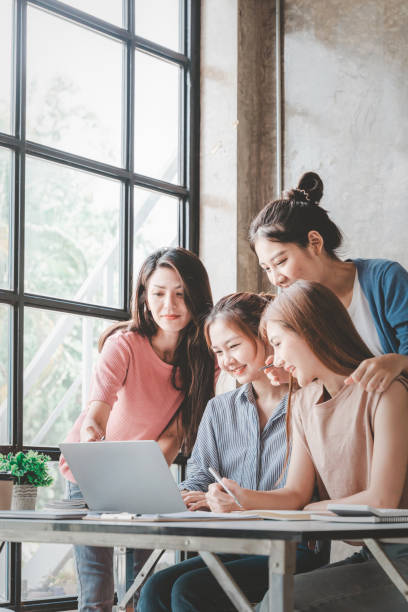 istock Four business women sharing ideas on work strategy by looking at data on laptop computer - Teamwork concept. 1400177209