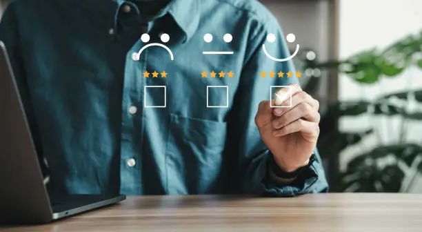 Photo of Businessman touching virtual screen on happy smiley face icon Rate the service experience on the online application. Customer Service and Satisfaction Concept The ratings are very impressive.