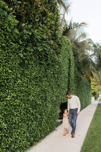 31-year-old american father walking while holding his 3-year-old daughter in palm beach, florida in the spring of 2022 - hedge multi ethnic group people holding hands imagens e fotografias de stock