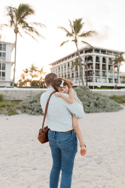 31-year-old american father walking while holding his 3-year-old daughter while having her head on his shoulder in palm beach, florida in the spring of 2022 - hedge multi ethnic group people holding hands imagens e fotografias de stock