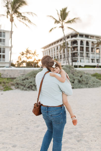 31-year-old american father walking while holding his 3-year-old daughter while having her head on his shoulder in palm beach, florida in the spring of 2022 - hedge multi ethnic group people holding hands imagens e fotografias de stock