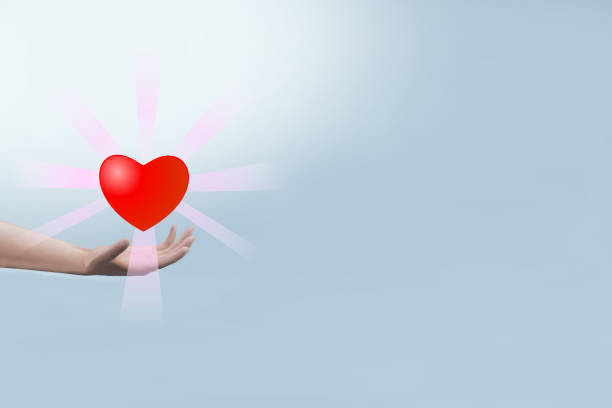 istock Hand holding heart shape with light ray on blue background. 1400178294
