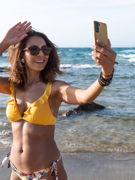 istock Hispanic woman on the beach making video call 1400178320