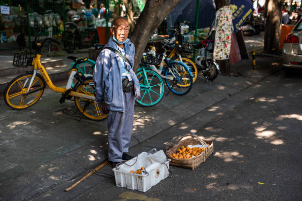 Chinese senior man selling Loquat in the street stock photo