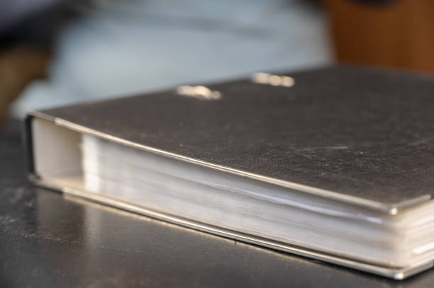 istock Gray file folder with binder. Papers are on a black desk. Close-up. Selective focus 1400186987