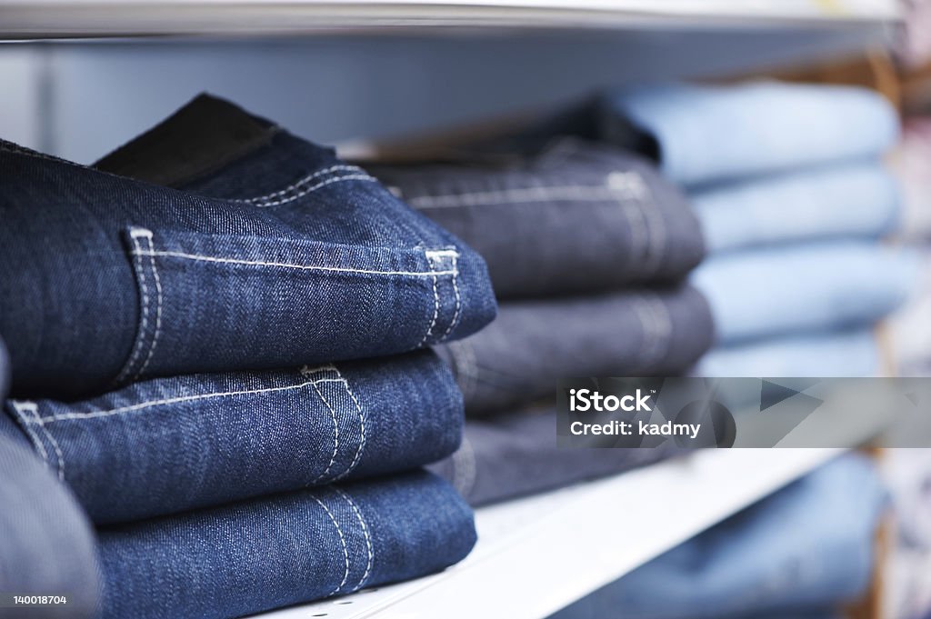 jeans clothes on shelf in shop shoping sale background theme. clothes on hanger in shop Jeans Stock Photo